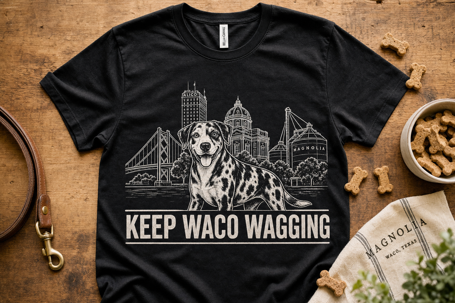 Keep Waco Wagging — Catahoula edition tee on a wood table with leash and dog treats